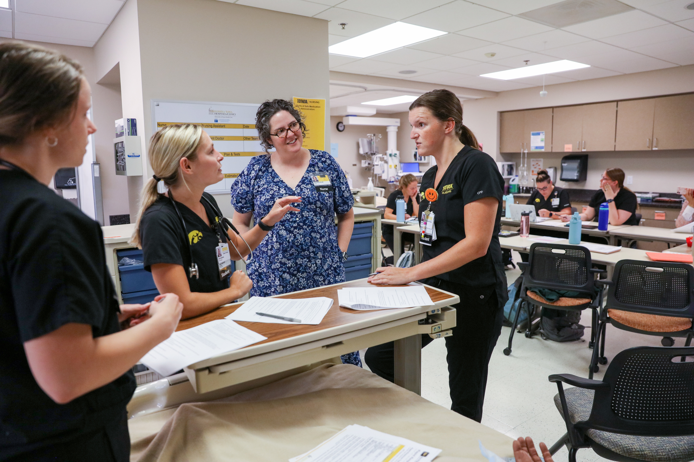 NCEC co-director Katie Knox (06BSN, 11MSN, 21PHD) (center) talks through a scenario with MSN–Entry into Practice students in June 2023. The members of the first cohort come from a wide variety of academic and professional backgrounds, from health and human physiology to teaching. 