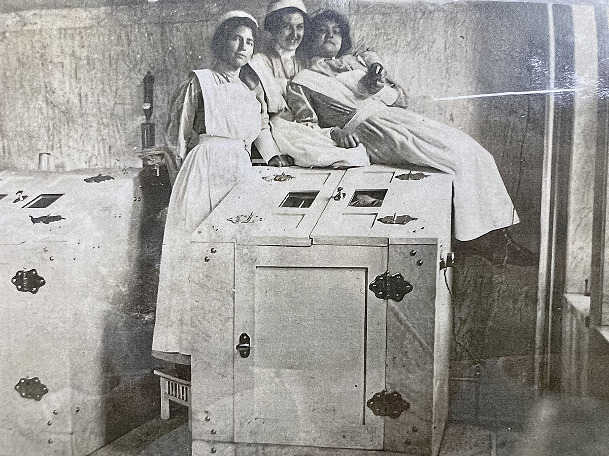 students sitting on electric cabinet, early 1900s