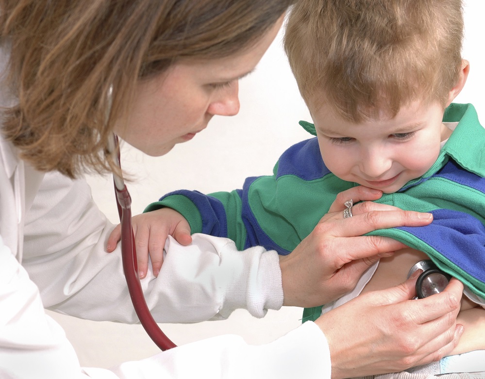 A pediatrics nurse examining a boy patient