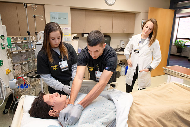 An instructor observing students in the simulation lab