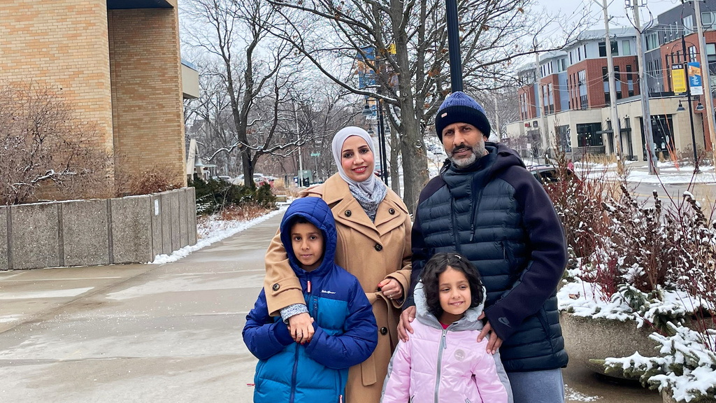 Saida Jaboob and her family in front of her Dare to Discover banner in downtown Iowa City. 